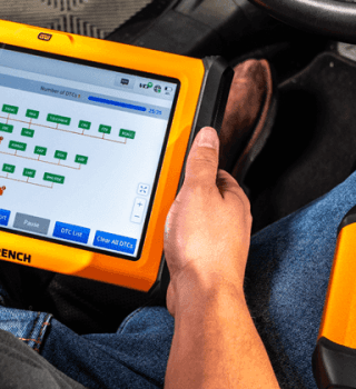 Male automotive technician using GWSMART10 diagnostic tablet and GWSMARTBT diagnostic scan tool to read vehicle codes