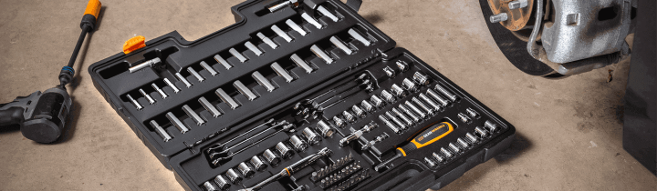 GEARWRENCH mechanics tool sets in a black blowmold case open on the floor of a garage