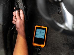Man plugging in the GWSMART05 to a vehicle's VCI port to diagnose issues with a vehicle