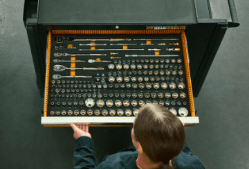 Man looking down into his GEARWRENCH tool storage a a GEARWRENCH modular tool set in the drawer.