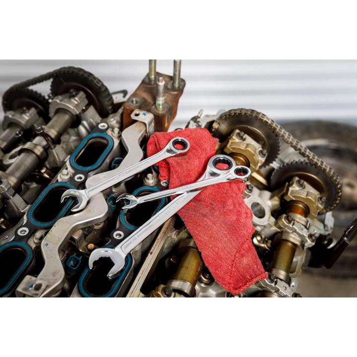 Image of the GEARWRENCH  8 Piece 72-Tooth 12 Point Open End Ratcheting Combination SAE Wrench Set with some of the wrenches laying on a car engine