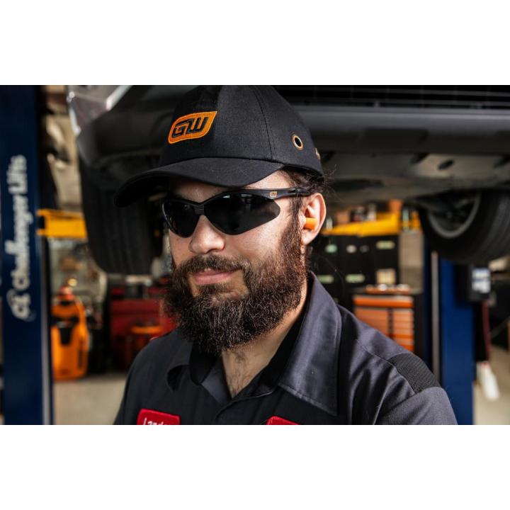 Image of the  Black Frame Safety Glasses - Tinted Lenses with a person wearing them in a garage setting